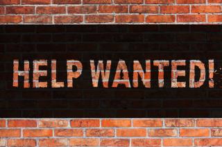 help wanted sign on brick wall 