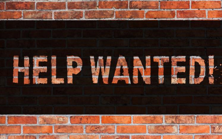 help wanted sign on brick wall 